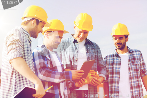 Image of group of smiling builders with tablet pc outdoors