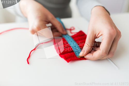 Image of woman with knitting on needle and measuring tape