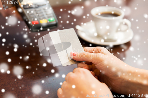 Image of close up of hands with credit card reader at cafe