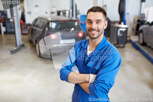 Image of happy auto mechanic man or smith at car workshop