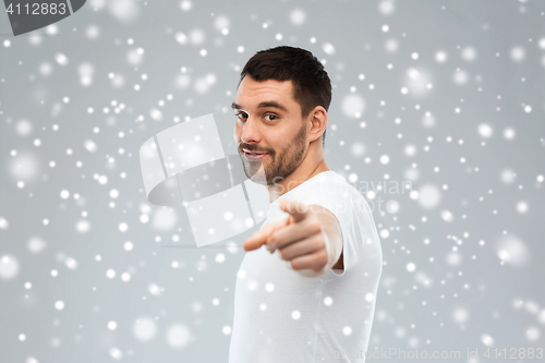 Image of man pointing finger to you over snow background