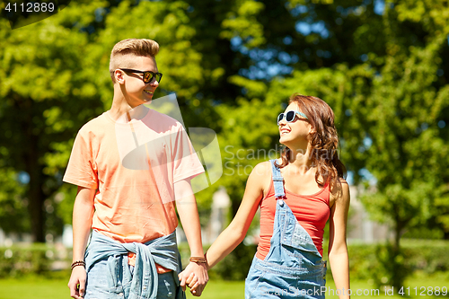 Image of happy teenage couple walking at summer park