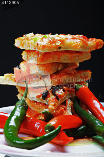 Image of Pizza and chili against dark background