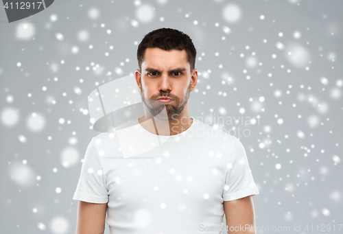 Image of man with funny angry face over snow background