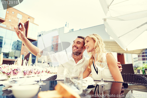 Image of couple taking selfie with smatphone at restaurant