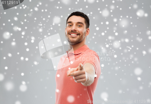Image of man pointing finger to you over snow background