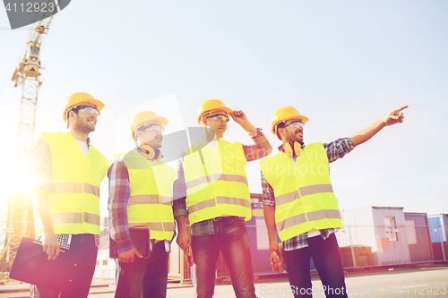 Image of group of smiling builders with tablet pc outdoors