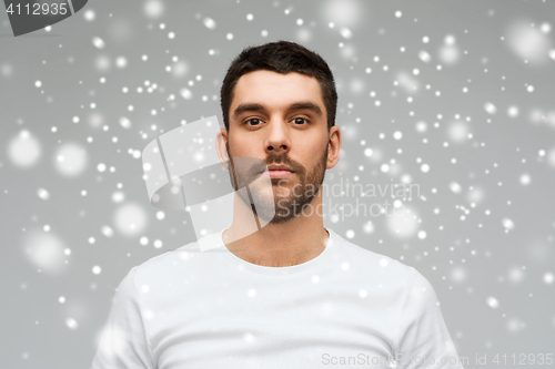 Image of young man portrait over snow background