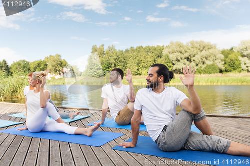 Image of people making yoga in half lord of the fishes pose