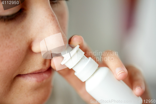 Image of close up of sick woman using nasal spray