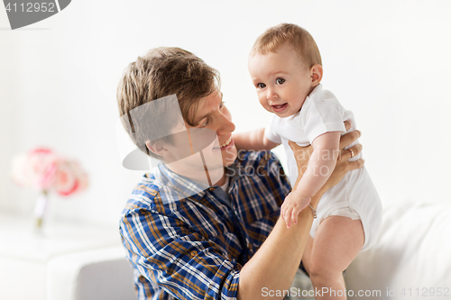 Image of happy young father with little baby at home