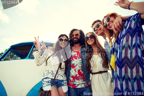 Image of hippie friends over minivan car showing peace sign