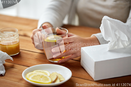 Image of close up of ill woman drinking tea with lemon