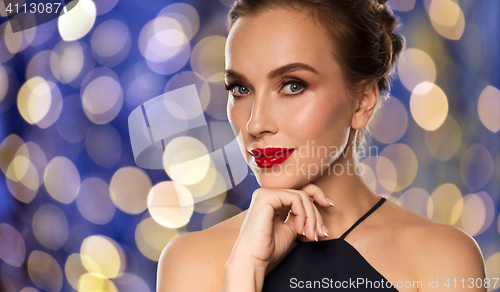 Image of beautiful woman in black over dark background