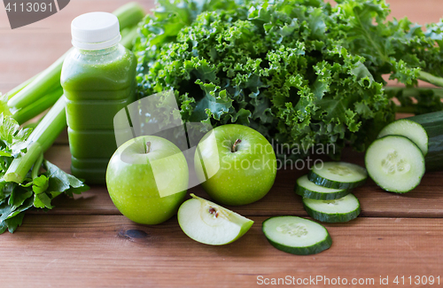 Image of close up of bottle with green juice and vegetables