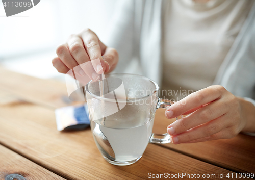 Image of woman stirring medication in cup of water