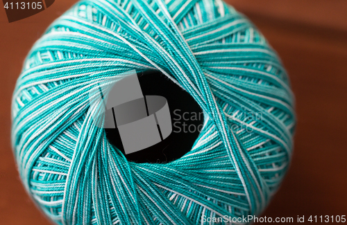 Image of close up of turquoise knitting yarn ball on wood