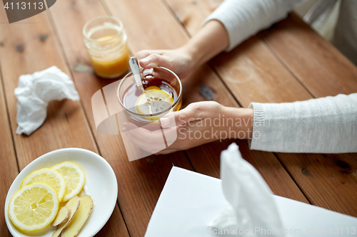 Image of ill woman drinking tea with lemon and ginger