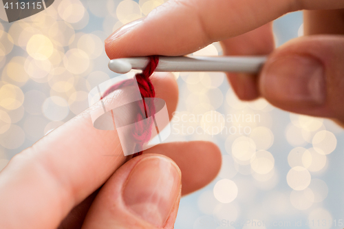 Image of close up of hands knitting with crochet hook