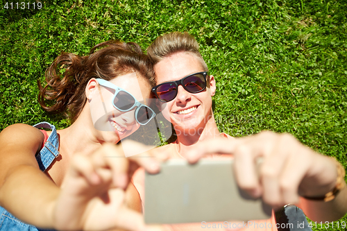 Image of happy couple taking selfie on smartphone at summer