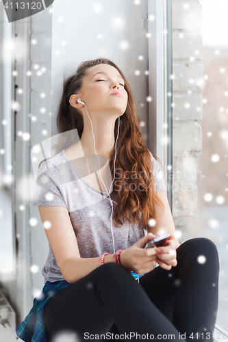 Image of teenage girl with smartphone and earphones