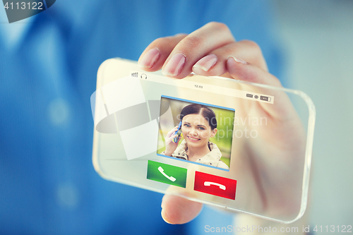 Image of close up of hand with incoming call on smartphone