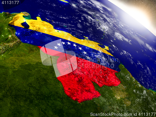 Image of Venezuela with flag in rising sun