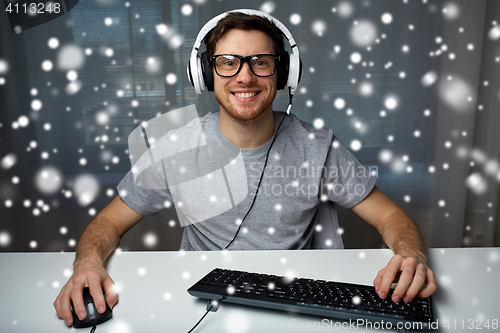 Image of man in headset playing computer video game at home