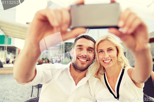 Image of couple taking selfie with smatphone at restaurant