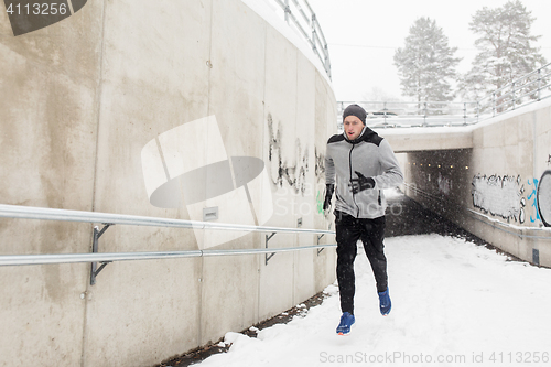 Image of man running out of subway tunnel in winter