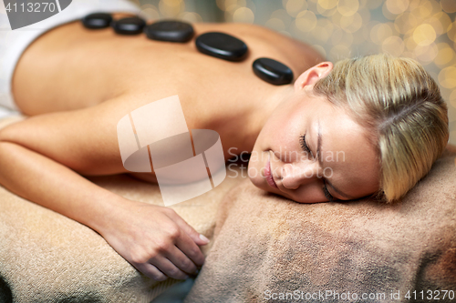 Image of close up of woman having hot stone massage in spa