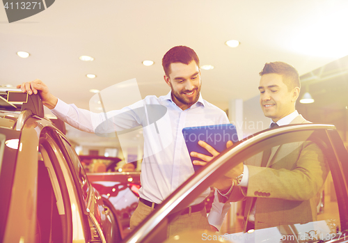 Image of happy man with car dealer in auto show or salon