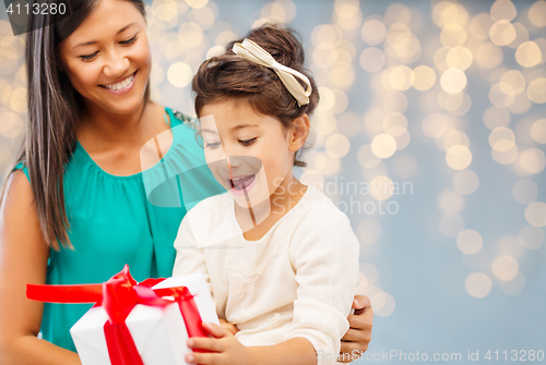 Image of happy mother and child girl with gift box