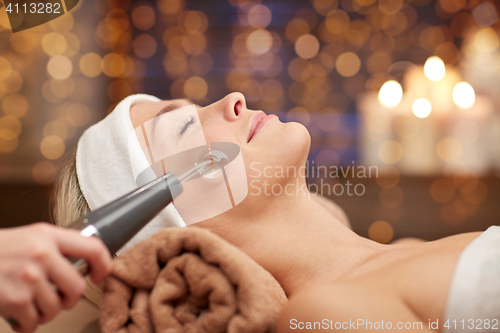 Image of close up of young woman having face massage in spa