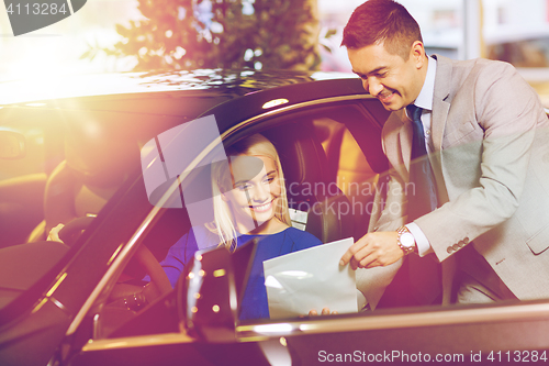 Image of happy woman with car dealer in auto show or salon