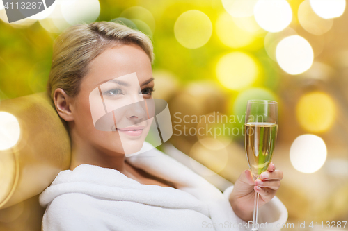 Image of beautiful young woman drinking champagne at spa