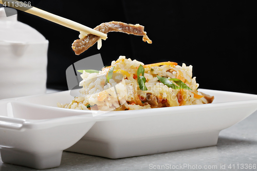 Image of Vietnamese pilaf with beef in a chopsticks