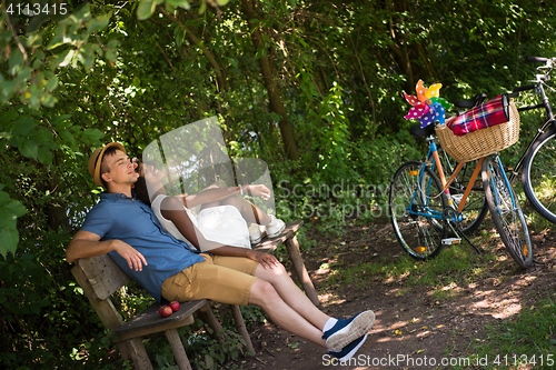 Image of Young multiethnic couple having a bike ride in nature