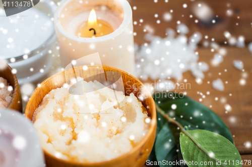 Image of close up of natural body scrub and candle on wood