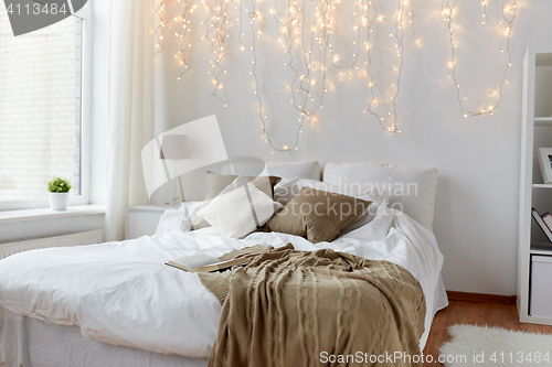 Image of bedroom with bed and christmas garland at home