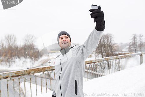 Image of man taking selfie with smartphone in winter 