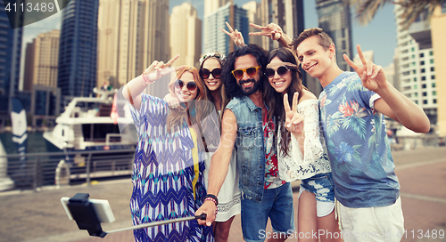 Image of hippie friends with smartphone on selfie stick