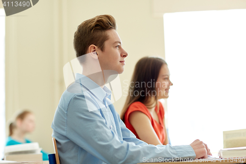 Image of group of students with notebooks at school lesson