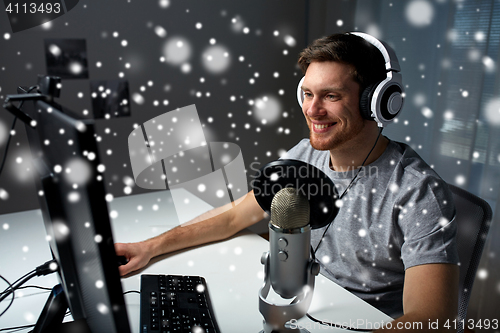 Image of man in headset playing computer video game at home