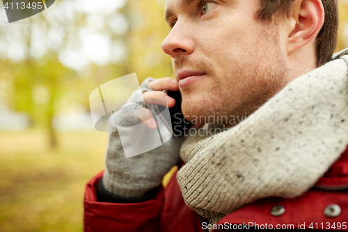 Image of close up of man with smartphone calling in autumn