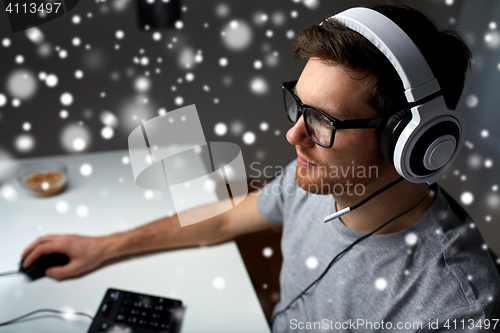 Image of man in headset playing computer video game at home