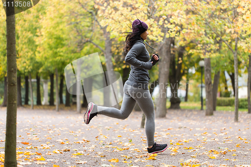 Image of close up of young woman running in autumn park