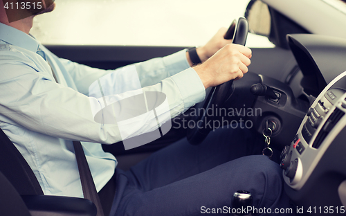 Image of close up of young man driving car