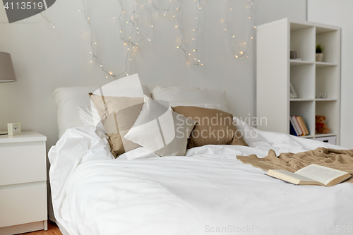 Image of bedroom with bed and christmas garland at home