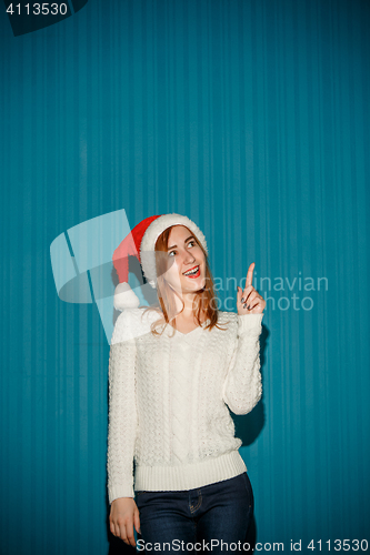 Image of Surprised christmas girl wearing a santa hat